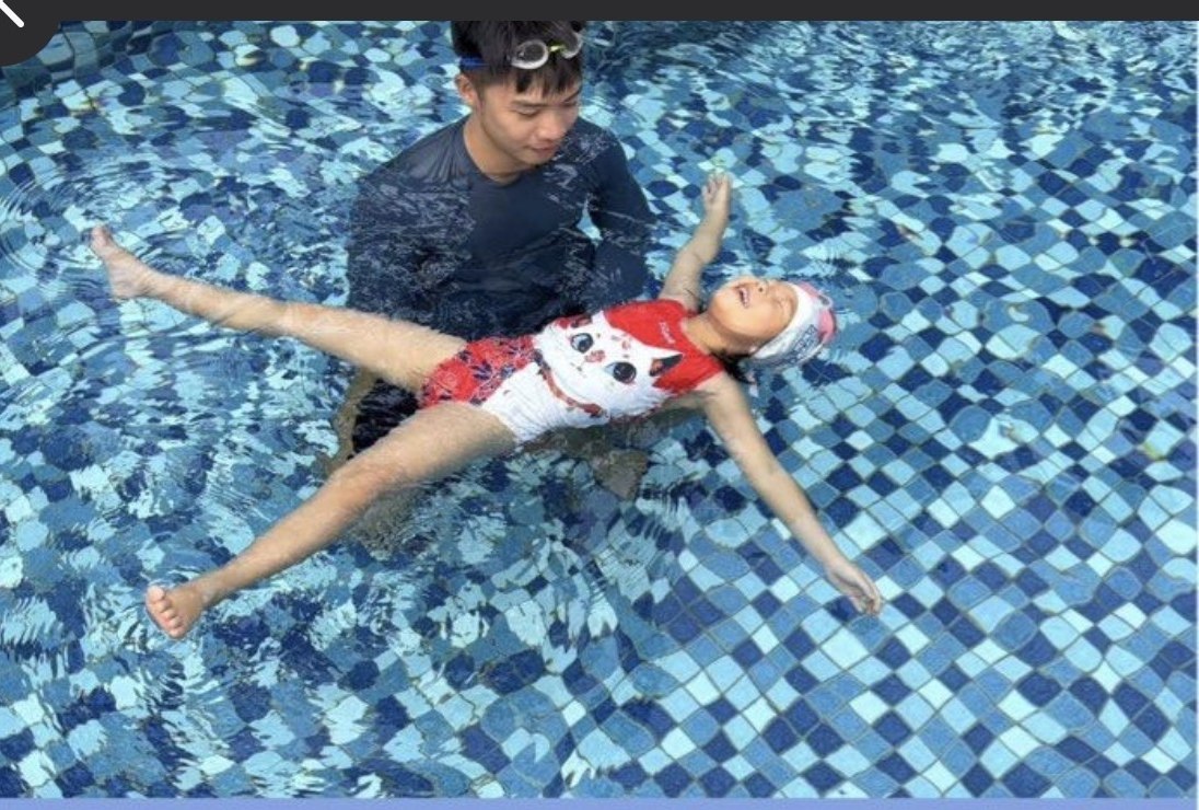 Child practising back float during a private swimming lesson
